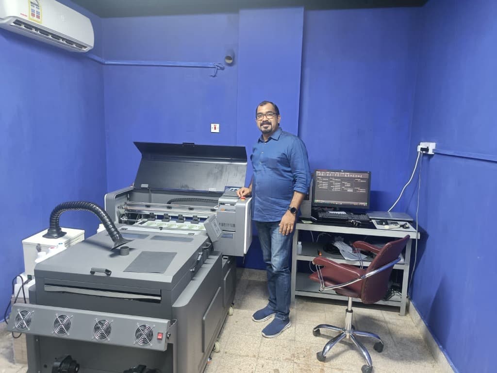 Leadership of Blue Sky Trading WLL standing proudly next to a large format commercial printing machine